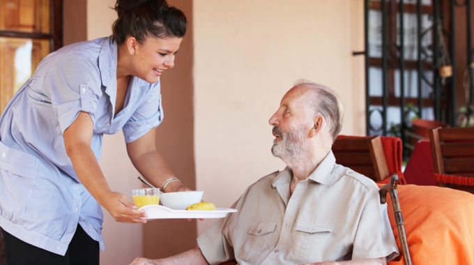 A Senior Receiving A Home Cooked Meal From A Home Care Aide