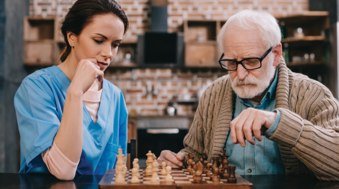 Image Of A Home Health Nurse Playing A Game With A Medicare Patient.