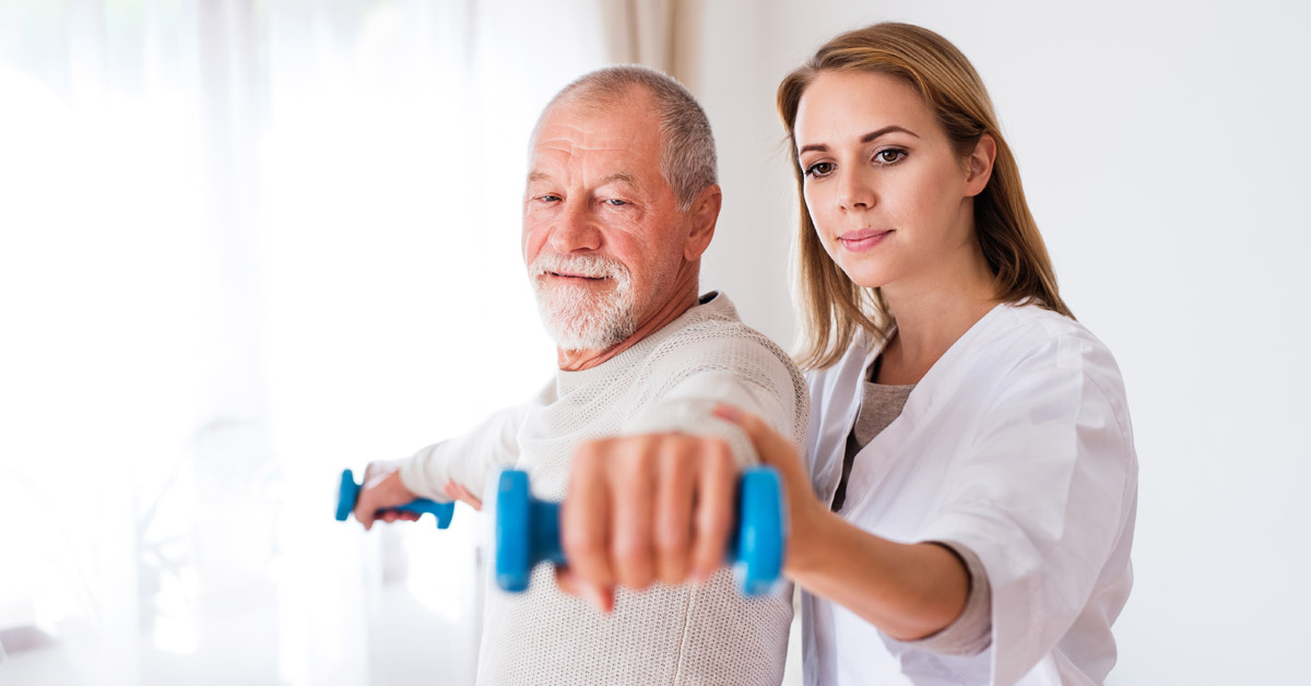 Nurse Helping A Senior Man With Physical Therapy Exercises.