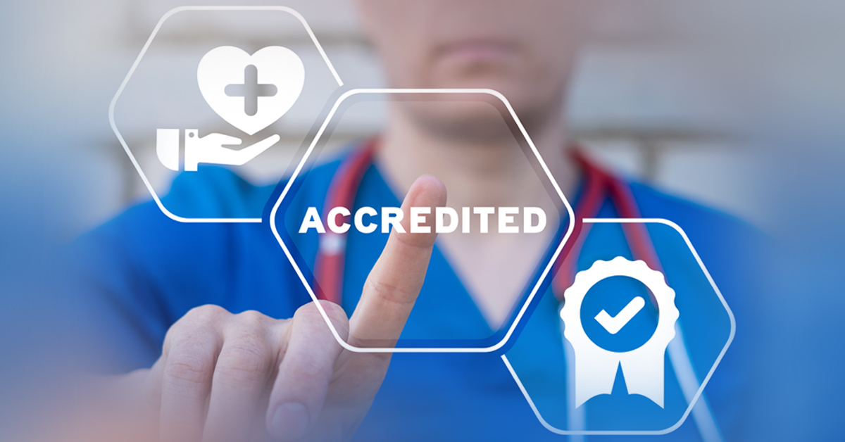 Male Nurse Pointing Out The Word Accredited.