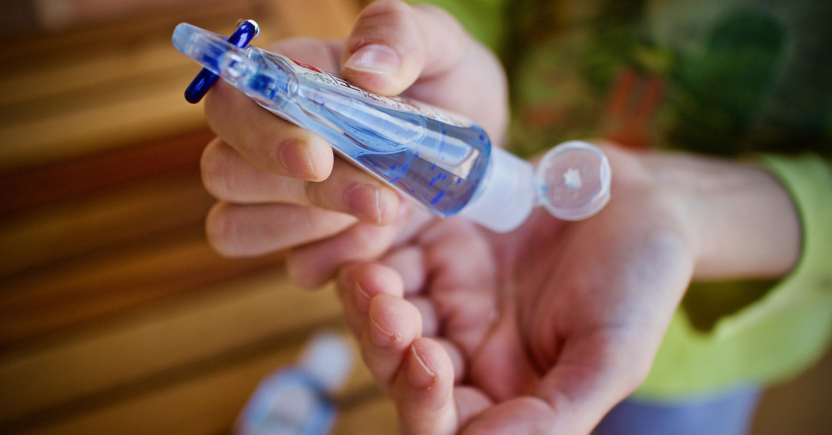 Lady Applying Hand Sanitizer To Her Hands.