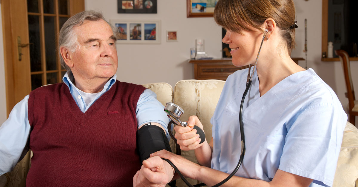 Nurse Checking Blood Pressure Of A Senior Man In His Home.