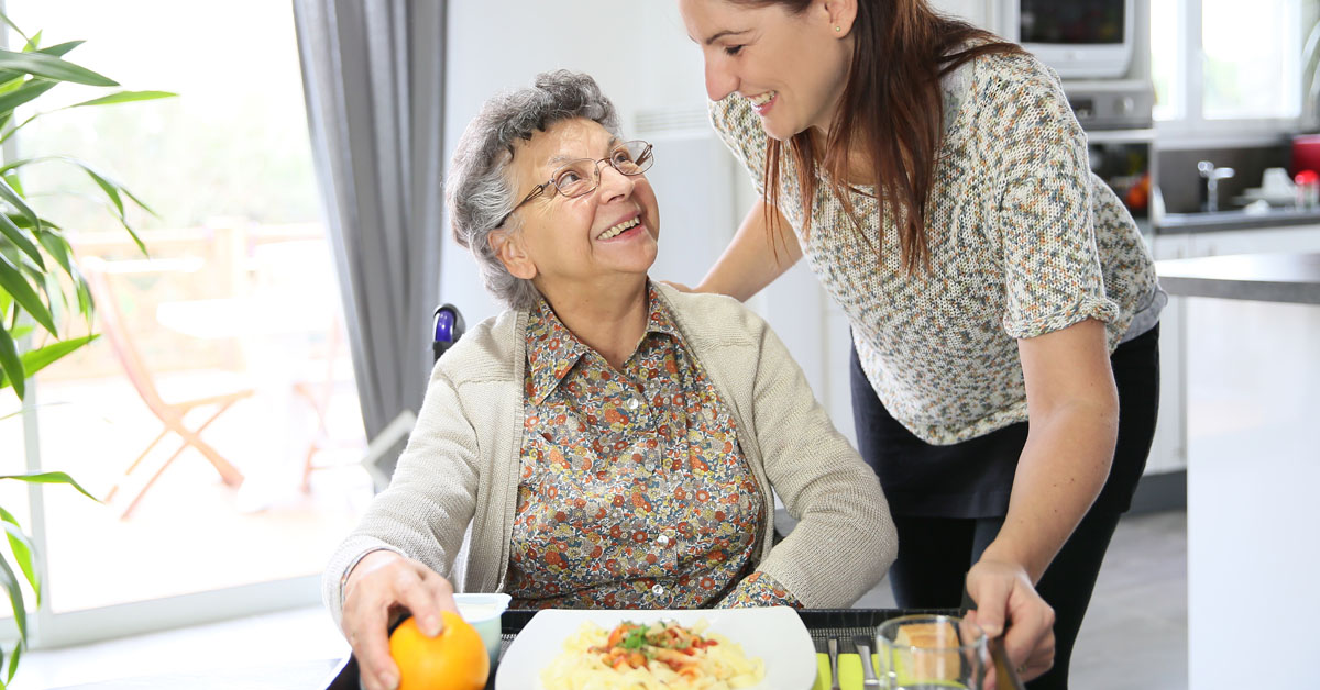 Caregiver Daughter Preparing Breakfast For Mother.